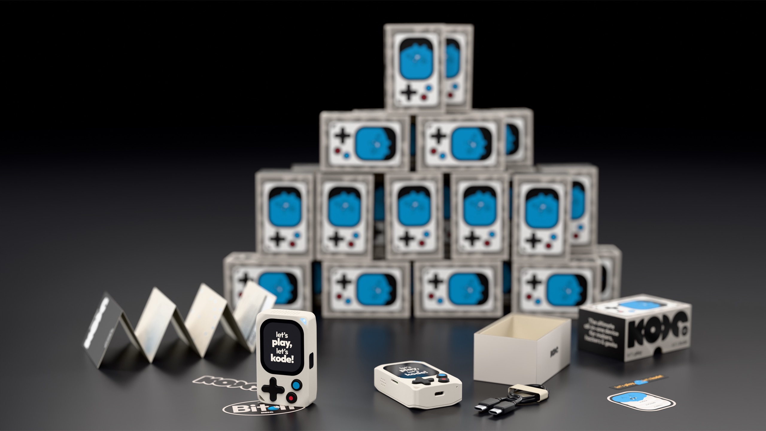 A pyramid of Kode Dot boxes with everything that ships inside laid out in front
