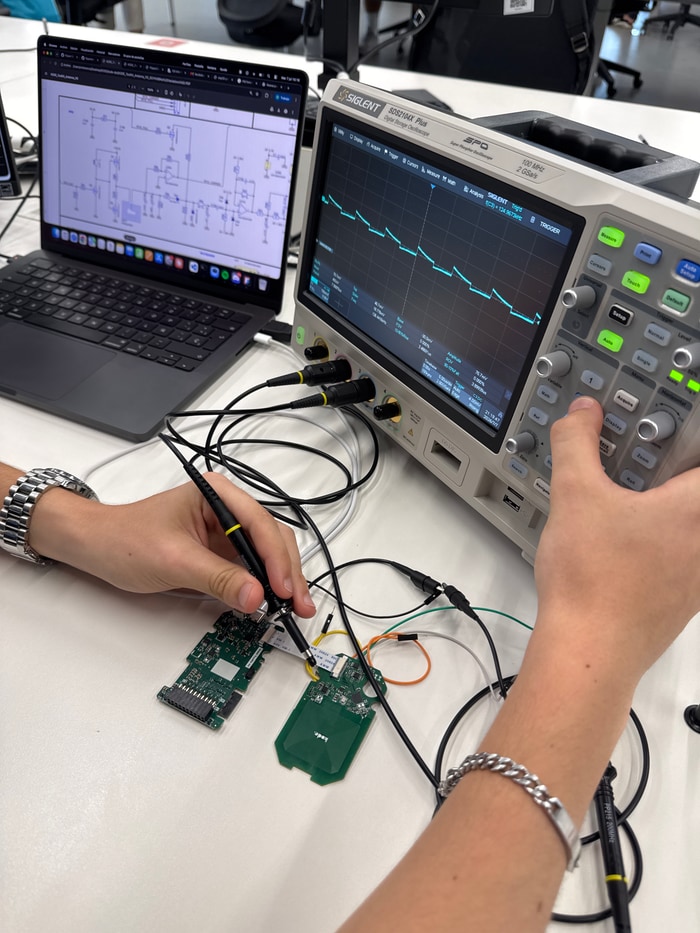 Validating the Kode Dot main PCB with an oscilloscope, the schematic open on a laptop